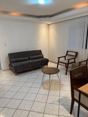a living room with a couch and a table at Pousada Araúna Angra in Angra dos Reis