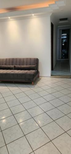 a couch sitting in a room with a tile floor at Pousada Araúna Angra in Angra dos Reis