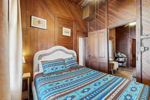 una camera da letto con un letto in una stanza con pareti in legno di Fabulous oceanfront home with ocean view, WiFi, washer/dryer, & central AC a Summer Haven