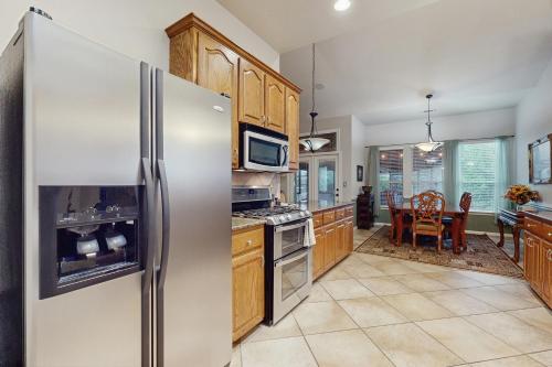 a kitchen with a stainless steel refrigerator and a table at Pomegranate Leisure in Cedar Park