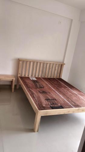 a wooden bed sitting in a corner of a room at Dodamarg Heights in Dodamarg