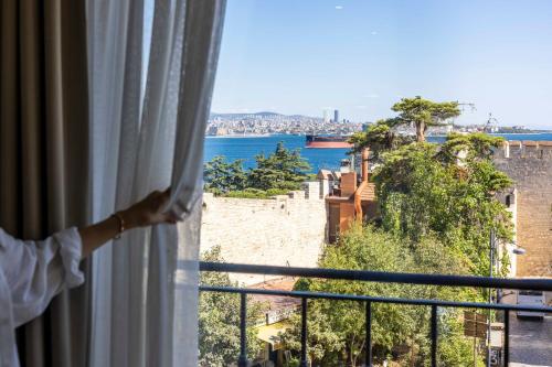 a person looking out of a window at the ocean at Joyway Hotels Istanbul Sultanahmet in Istanbul