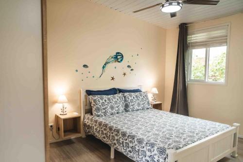 a bedroom with a bed with a blue mermaid on the wall at Matira Blue House in Bora Bora
