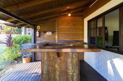 a large wooden bar on the outside of a house at Casas Valley Design - Praia do Rosa/SC in Praia do Rosa