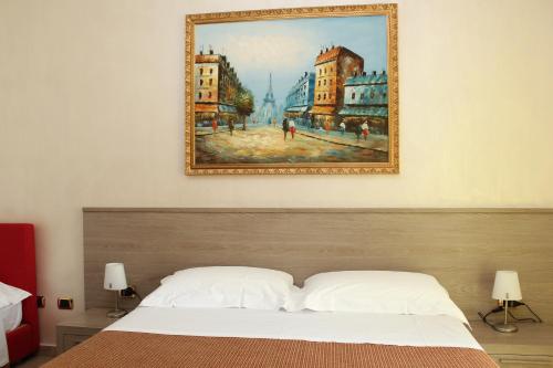 a painting hangs above a bed in a bedroom at Suitedelmare in Gallipoli