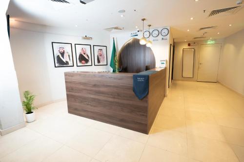 a lobby of a store with a counter with pictures on the wall at فندق ديمورا Dimora Hotel in Makkah