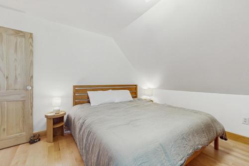 a bedroom with a large bed with a wooden headboard at Turner Hill Cottage in West Townshend