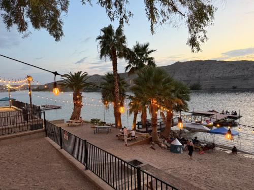 a beach with palm trees and a boat in the water at Couples getaway in Bullhead City