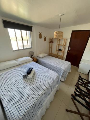 two beds in a hotel room with a phone on top at Maré suites in Fernando de Noronha