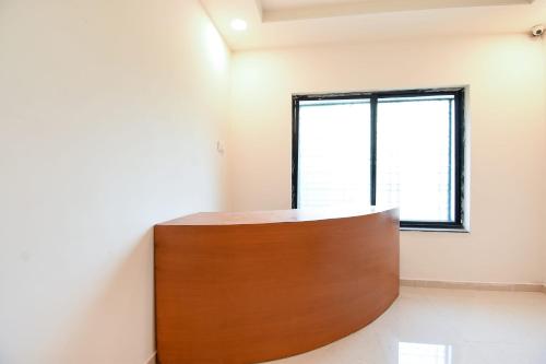 a room with a wooden partition with a window at Collection O White House Regency in Nagpur