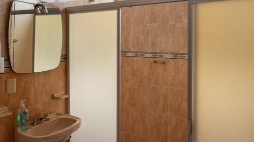 a bathroom with a sink and a shower with a mirror at Casa Centrica Con Estacionamiento in Cedro