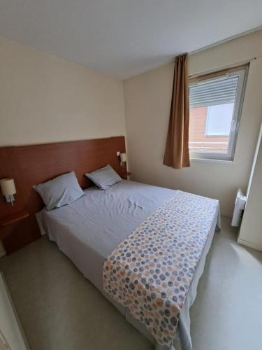 a bedroom with a large bed with a window at cottage Le Vau15 in Chaveignes