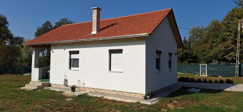 a small white house with a red roof at Levendula Apartman Bélapátfalva in Bélapátfalva