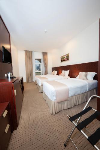 a hotel room with two beds and a flat screen tv at فندق ديمورا Dimora Hotel in Mecca