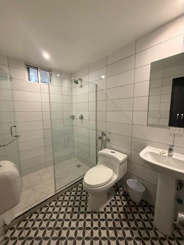 a bathroom with a toilet and a shower and a sink at Residencial & Hotel Palazzo in Panama City