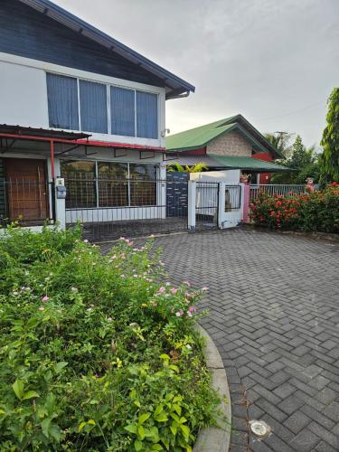 a house with a brick driveway in front of a building at Ivy's Place in Paramaribo