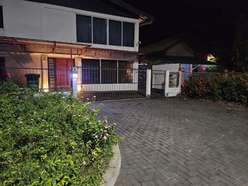 a house with a brick driveway in front of a building at Ivy's Place in Paramaribo
