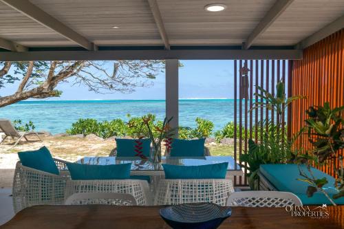 a patio with a view of the ocean at Fare Nalu - 2BR Beach Bungalow in Haapiti