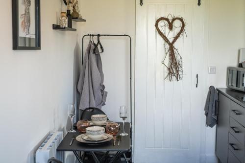 a table in a kitchen with a heart decoration on the wall at Farr North Lodge 1 By The Sea in Wick
