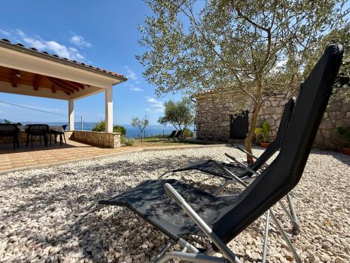a chair sitting on the gravel in front of a house at Holiday Home Vista Natura in Labin