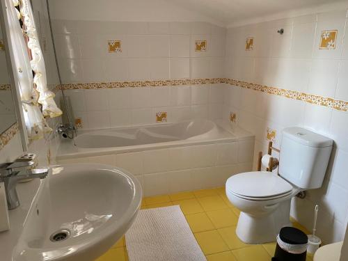 ein Badezimmer mit Badewanne, Toilette und Waschbecken in der Unterkunft First-Line Oceanfront House in Moledo in Moledo