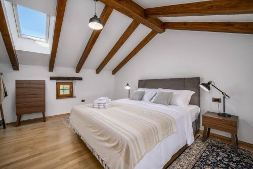 a bedroom with a large white bed and wooden ceilings at Villa Cangarela in Višnjan