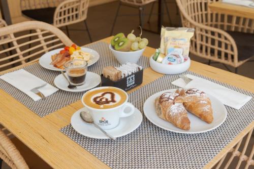 a table with cups of coffee and croissants on it at Il Piccolo Giardino GH ***Superior in Taormina