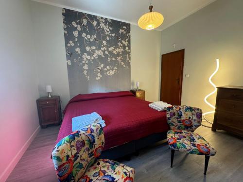 a bedroom with a red bed and a chair at Da Noi Trattoria Hotel in Vergato