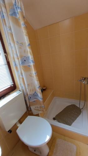 a bathroom with a toilet and a bath tub at Holiday home Mumi in SJJ
