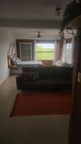 a living room with a couch and a bed at Mi Verde Horizonte in Utuado
