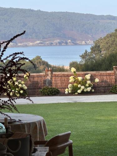 a garden with a fence and a table on a lawn at Balarés Hotel da Natureza in Ponteceso