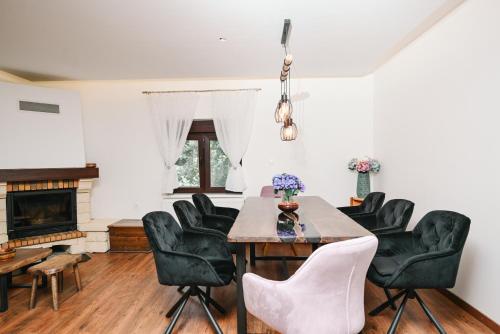 a dining room with a table and chairs and a fireplace at EMI Lokve in Homer