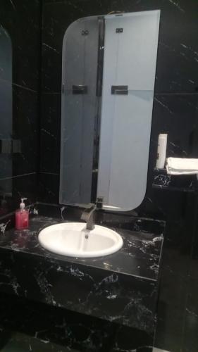 a bathroom with a sink and a mirror at وطن in Hafr Al Baten