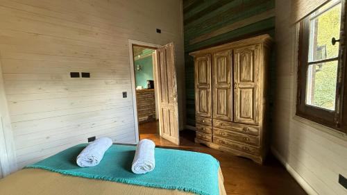 a bedroom with a bed with two towels on it at Departamentos de El Mercado in Villa La Angostura