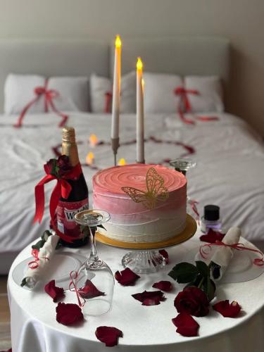 a pink birthday cake with two candles on a table at وطن in Hafr Al Baten