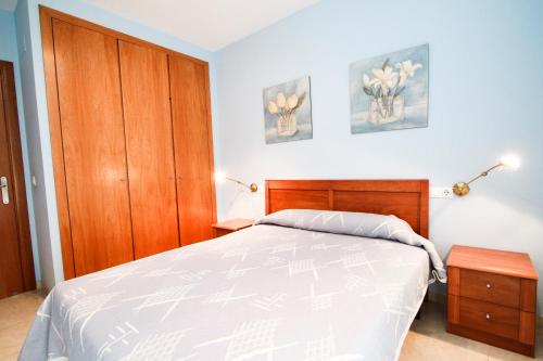 ラ・ピネーダにあるRoura Planet Costa Doradaのベッドルーム1室(ベッド1台付)、木製キャビネットが備わります。
