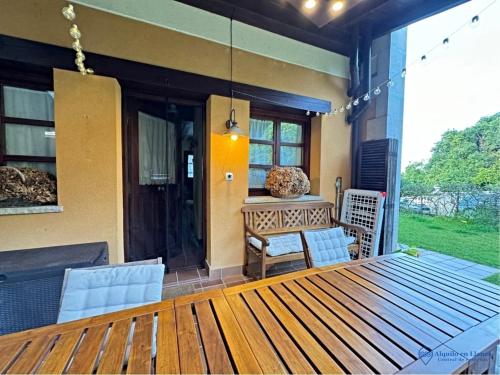 a wooden deck with a table and chairs on a porch at Vut la huertona in Pechón