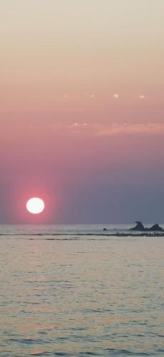 a sunset over the ocean with the sun in the sky at Scala dei Turchi Apartment in Realmonte