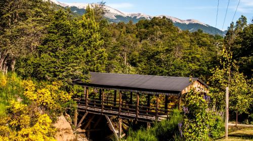 a wooden shelter with mountains in the background at Departamentos de El Mercado in Villa La Angostura