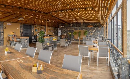 a large room with white chairs and tables and windows at ALOEVERA VILLAS & CAFA in Sayq