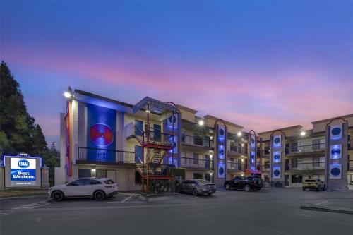 a parking lot with cars parked in front of a building at Best Western Courtesy Inn Hotel - Anaheim Resort at the Park in Anaheim