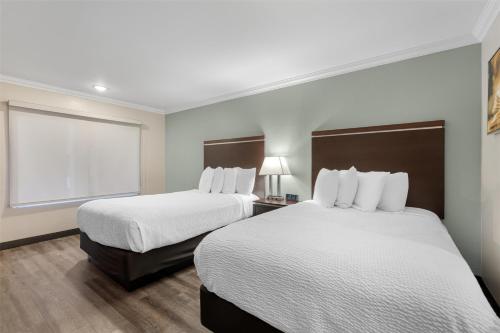 a hotel room with two beds and a window at Best Western Courtesy Inn Hotel - Anaheim Resort at the Park in Anaheim