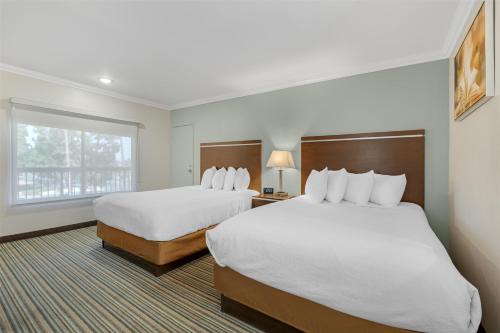 a hotel room with two beds and a window at Best Western Courtesy Inn Hotel - Anaheim Resort at the Park in Anaheim