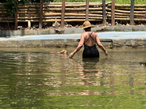 a woman standing in the water with a dog at Hotel Selva Cristal in San Carlos