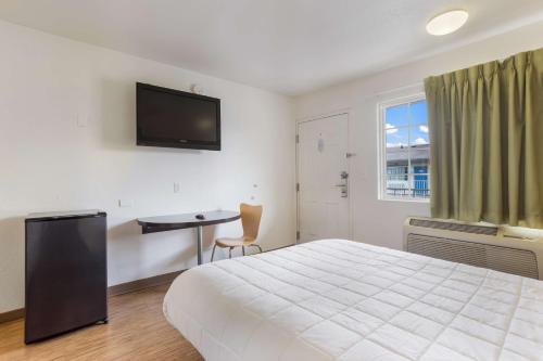 a bedroom with a bed and a desk and a television at Americas Best Value Inn Bowling Green in Bowling Green