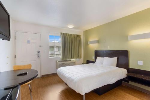a bedroom with a large bed with a desk and a window at Americas Best Value Inn Bowling Green in Bowling Green