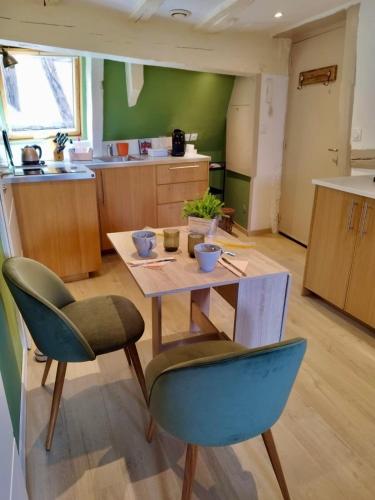 Les Corbelles, duplex hyper centre في ستراسبورغ: مطبخ به طاولة وكراسي في غرفة