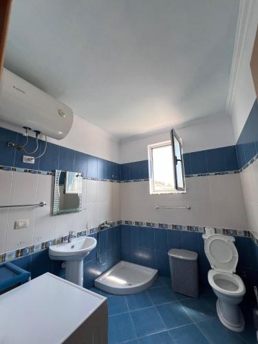 Ein blau-weißes Badezimmer mit Toilette und Waschbecken in der Unterkunft Ela's apartment in Orikum