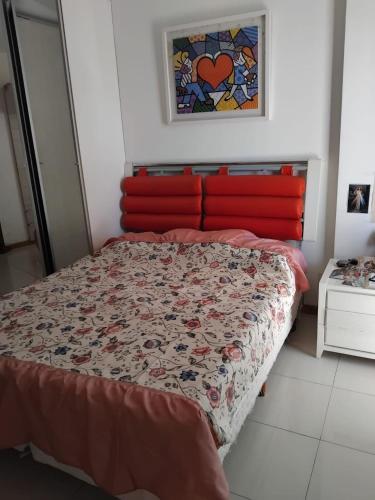 a bed with a red headboard in a bedroom at Murano Condominium in Curro Velho