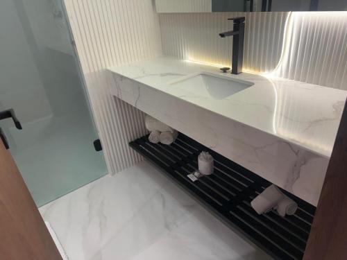 a white bathroom with a sink and a mirror at Américas Benidorm Hotel in Rio de Janeiro